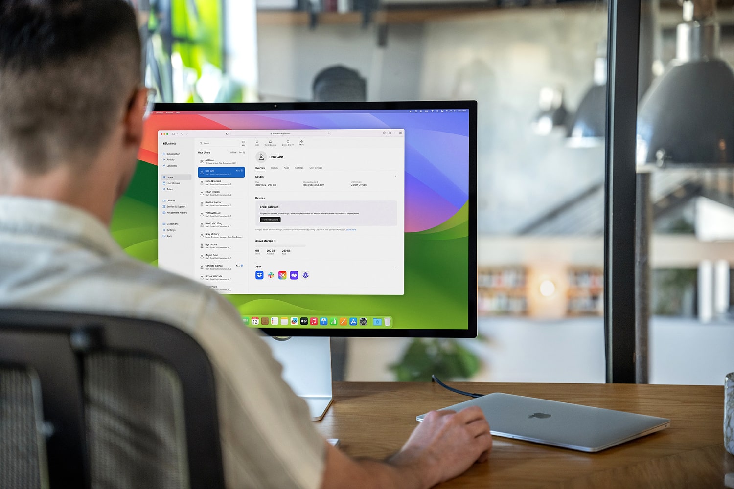 A person using an Apple MacBook Air with a Studio Display monitor.