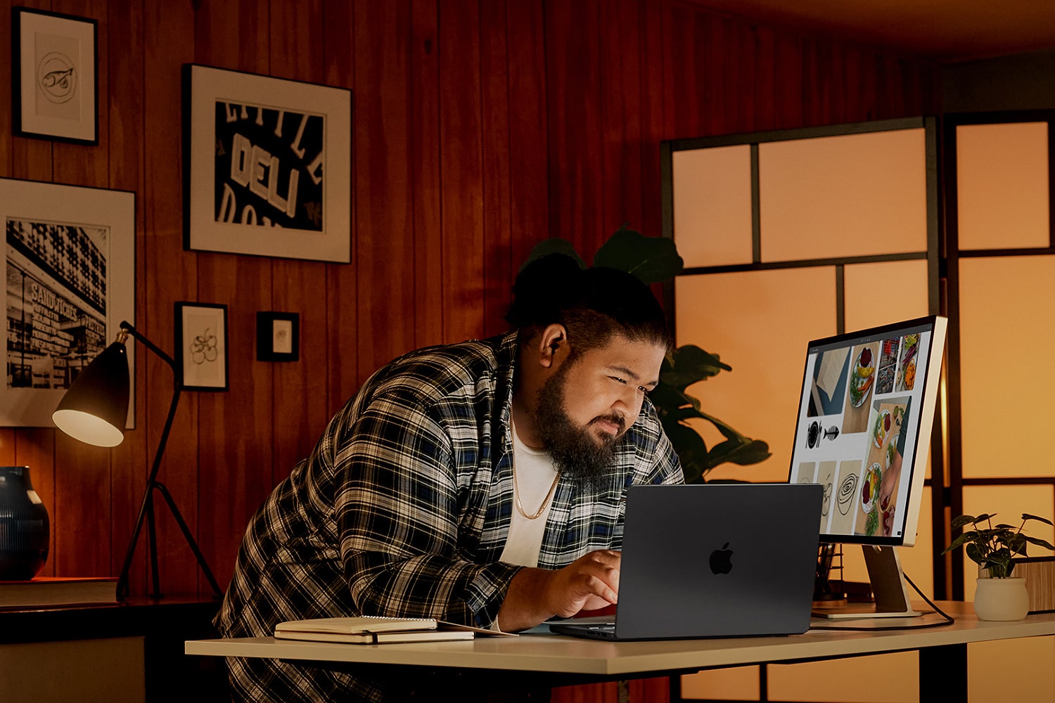 A person using a MacBook with an Apple Studio screen. AppleCare