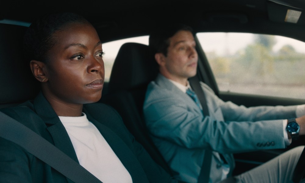 A woman sits in the passenger seat as the man drives in Carry-On.