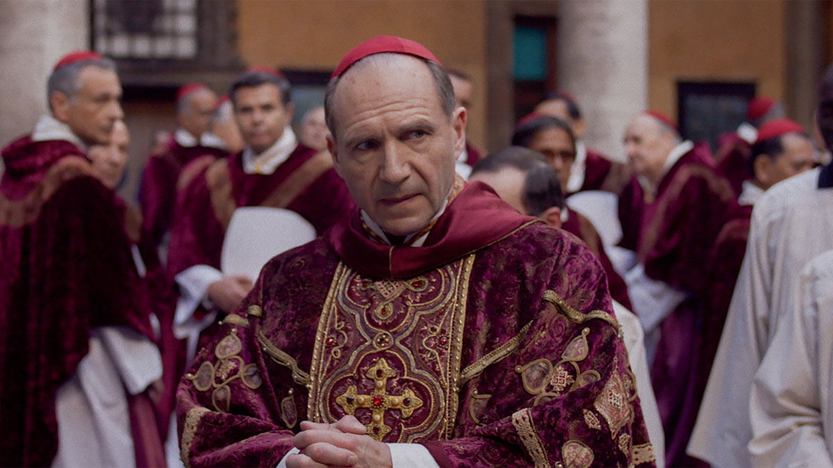 Ralph Fiennes stares in his clerical getup in a still from the movie Conclave.