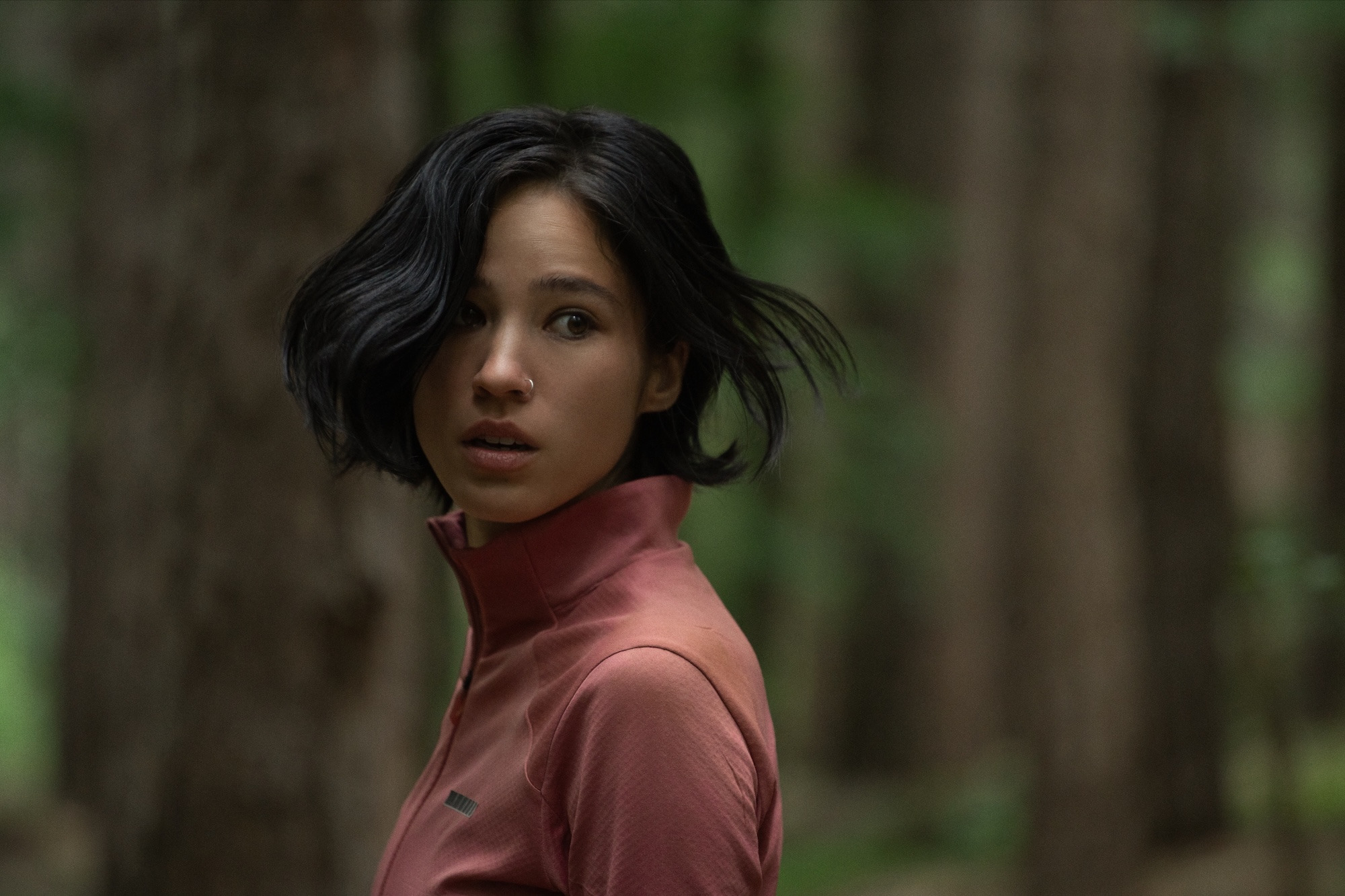 Une femme regarde en arrière en marchant dans les bois dans Don't Move.