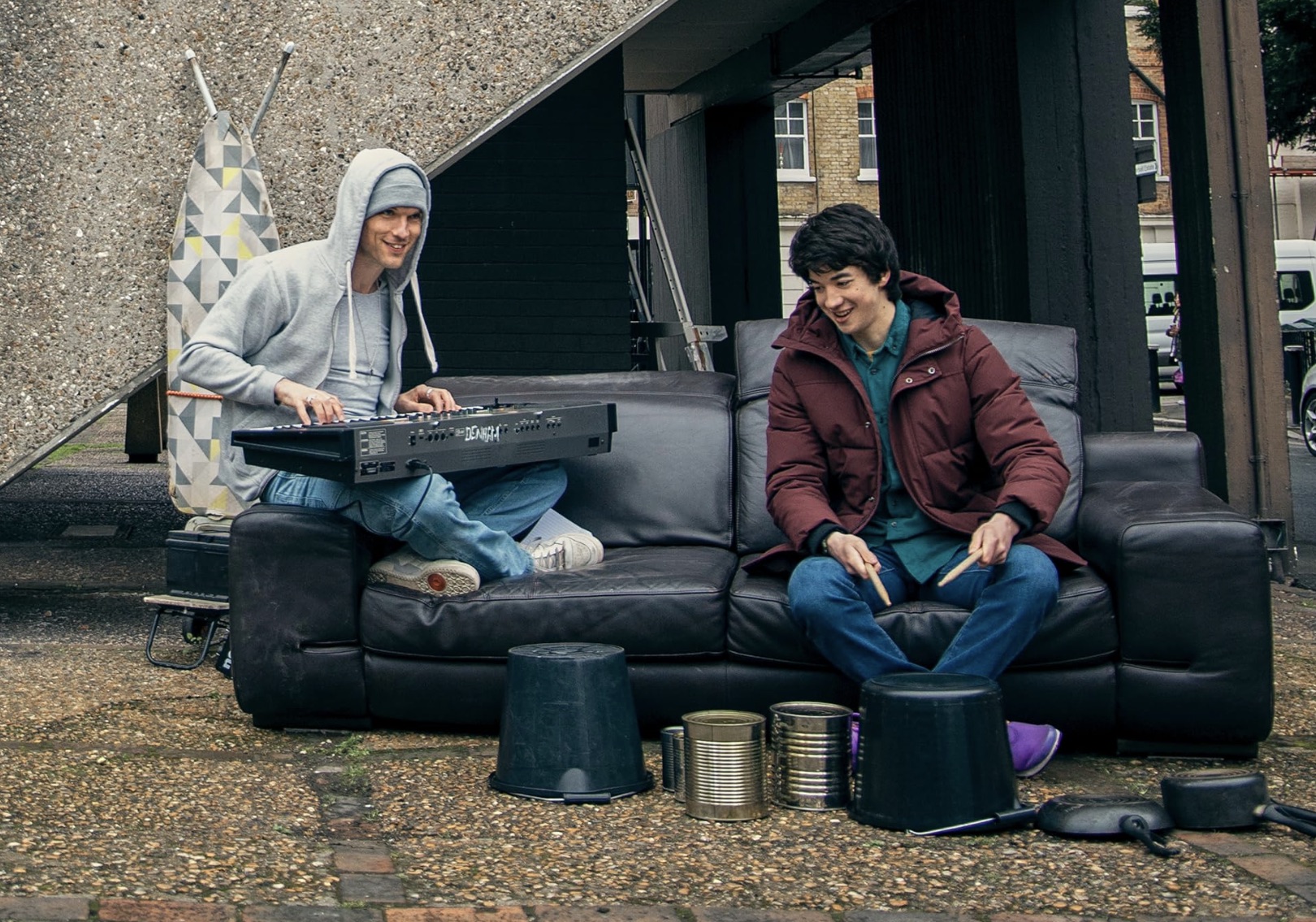 Deux personnes jouent de la musique assises sur un canapé dans I Used to Be Famous.