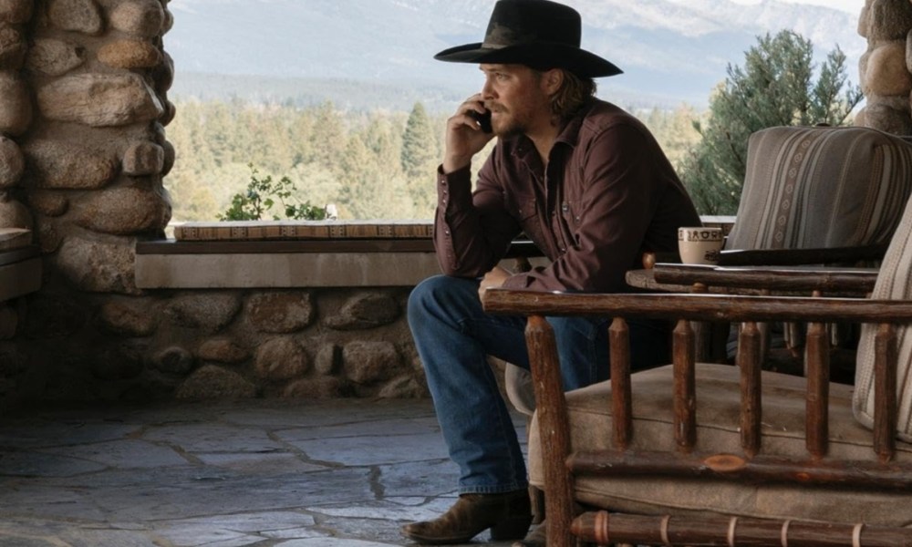 Kayce holds a phone up to his ear in Yellowstone.