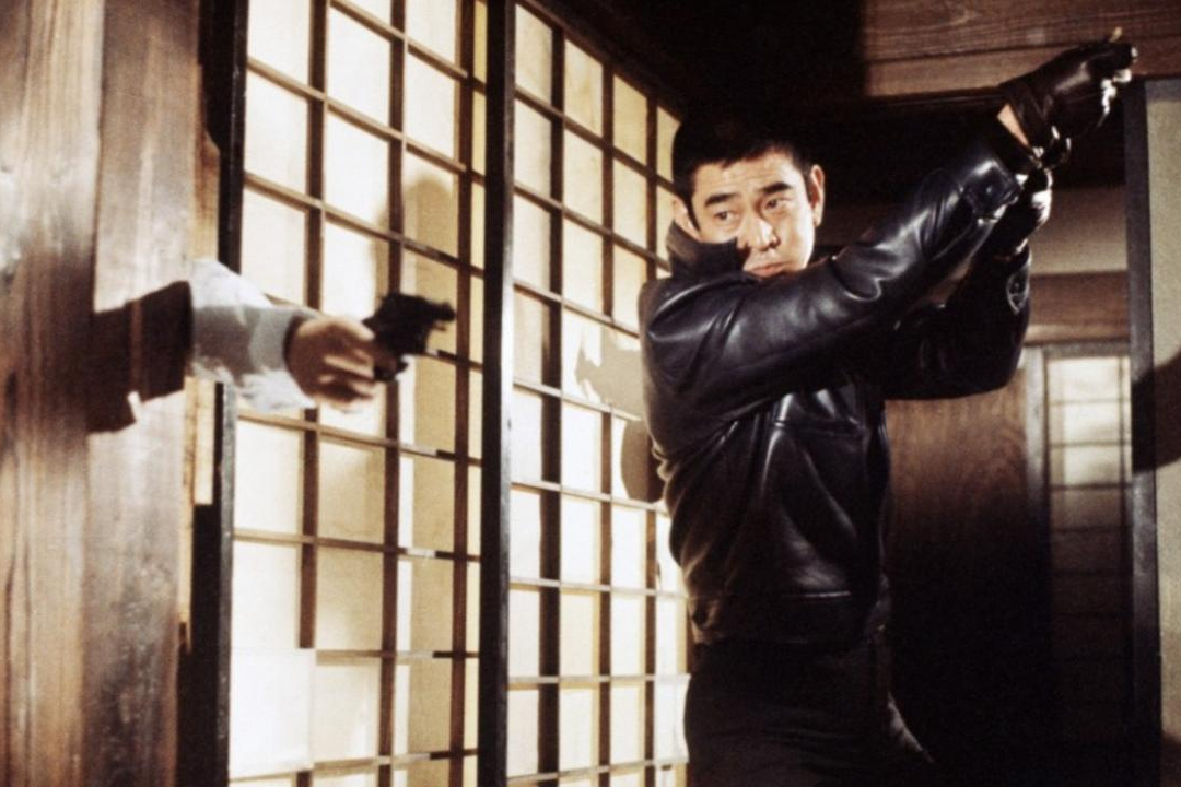 Ken Takakura blickt in „The Yakuza“ auf eine Waffe.