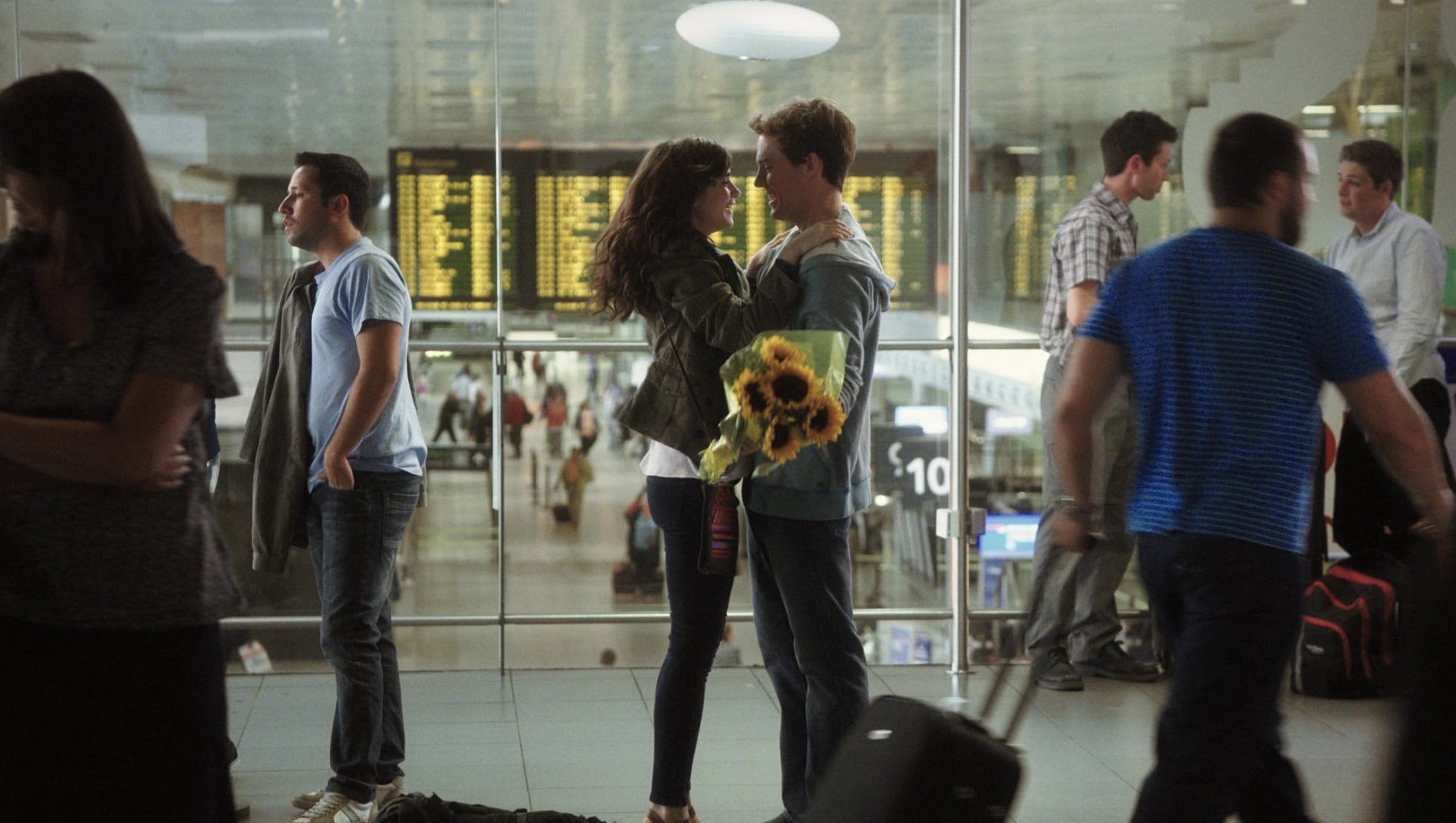 A woman and a man embrace in an airport in Love Rosie.