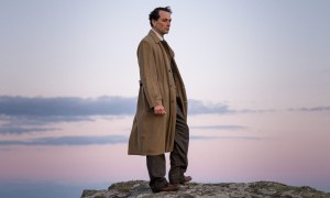 Matthew Rhys stands on a rocky plateau in Agatha Christie's Towards Zero.