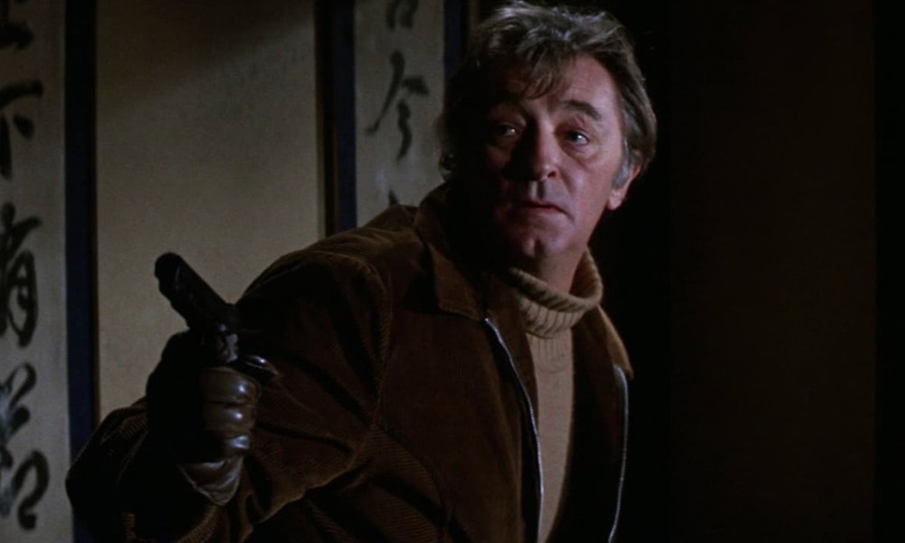 Robert Mitchum points a gun in The Yakuza.