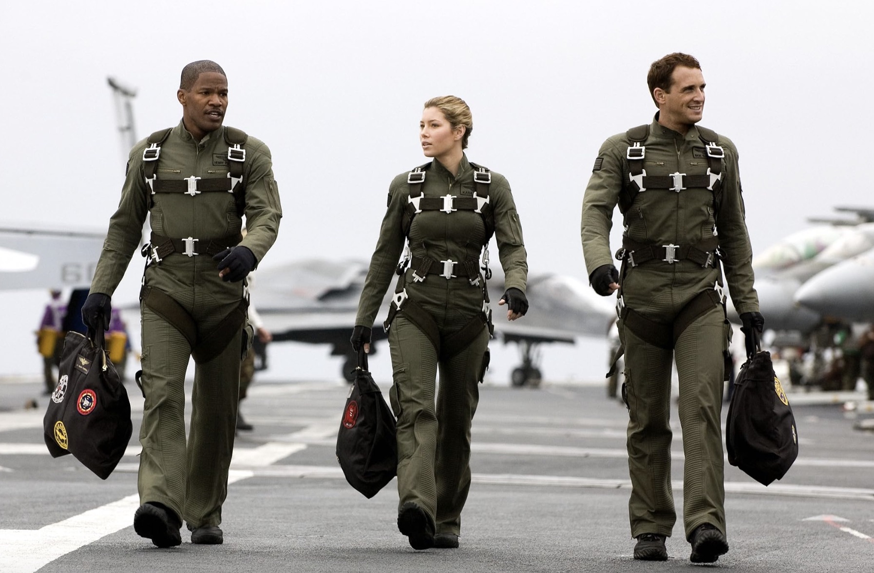 Three pilots walk down a runway next to each other in Stealth.