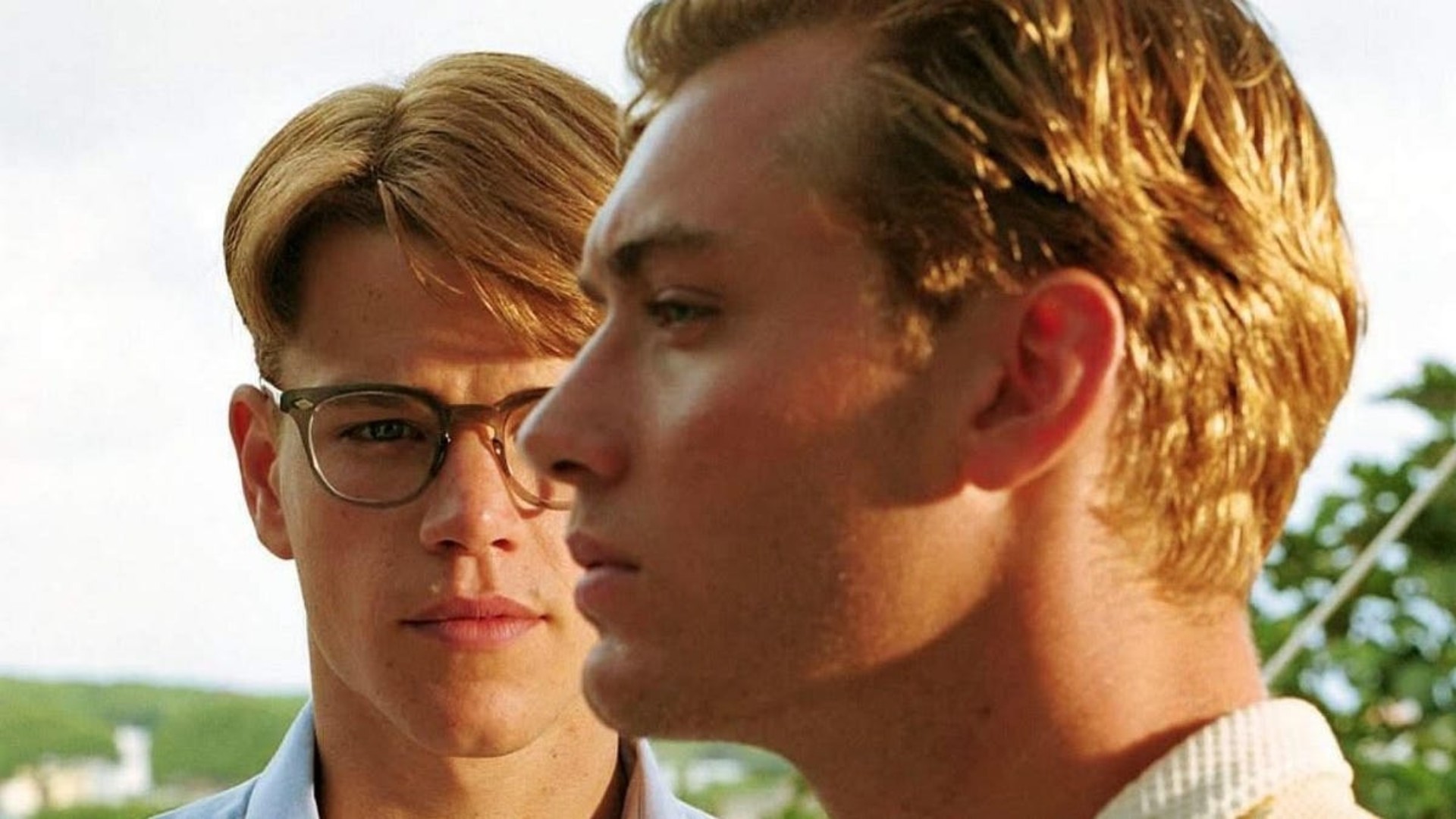 Matt Damon, al fondo, mira a Jude Law, de perfil en primer plano, en una imagen de la película The Talented Mr. Ripley.