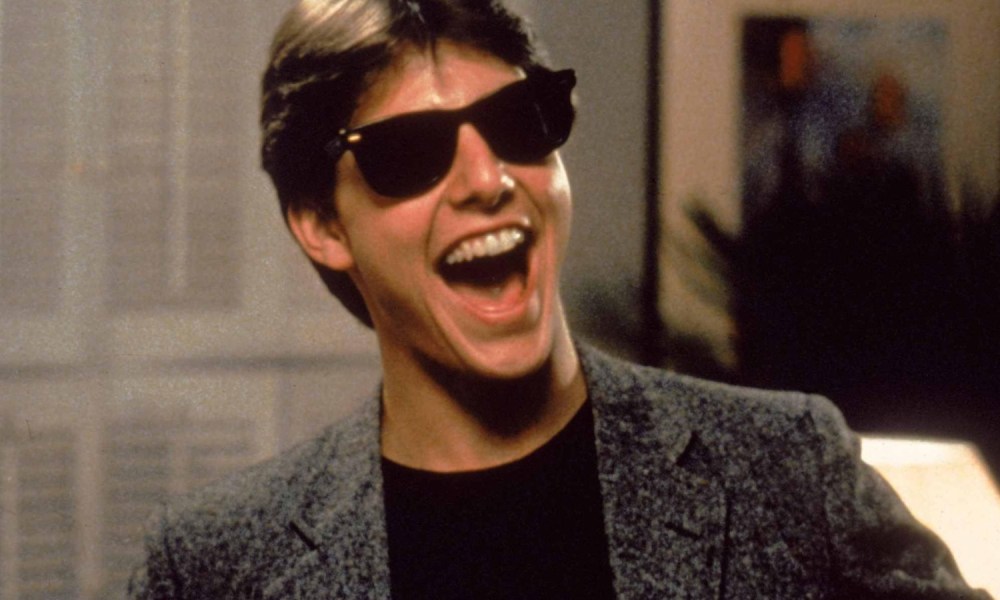 Tom Cruise smiles while wearing shades in Risky Business.