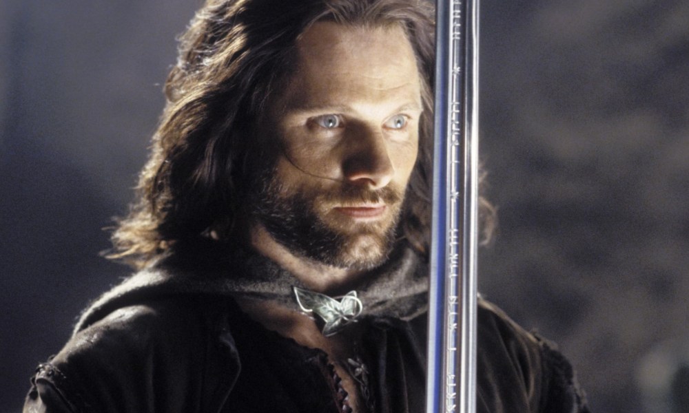 Viggo Mortenson wields a sword and stares.