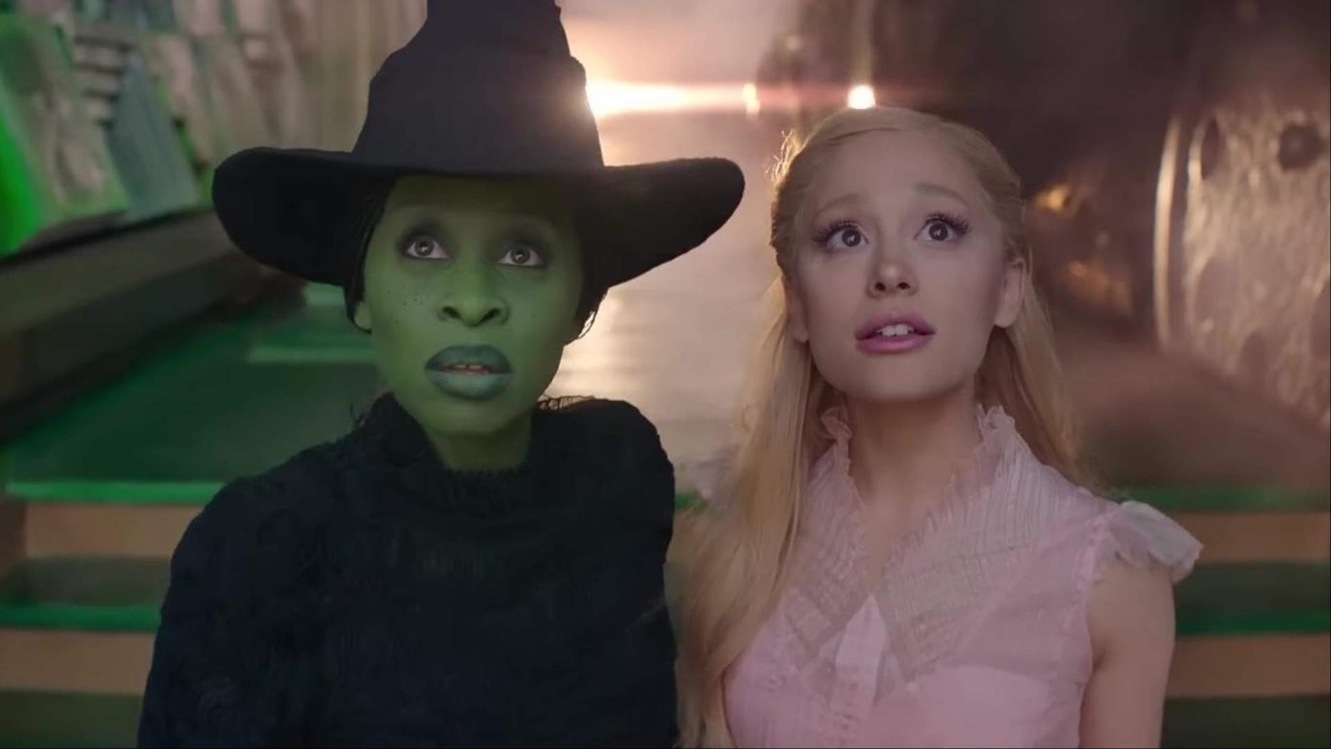 Cynthia Erivo et Arianda Grande se tiennent côte à côte et regardent une image du film Wicked.