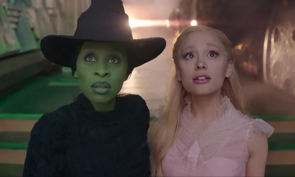 Elphaba and Glinda stand next to each other and stare in Wicked.