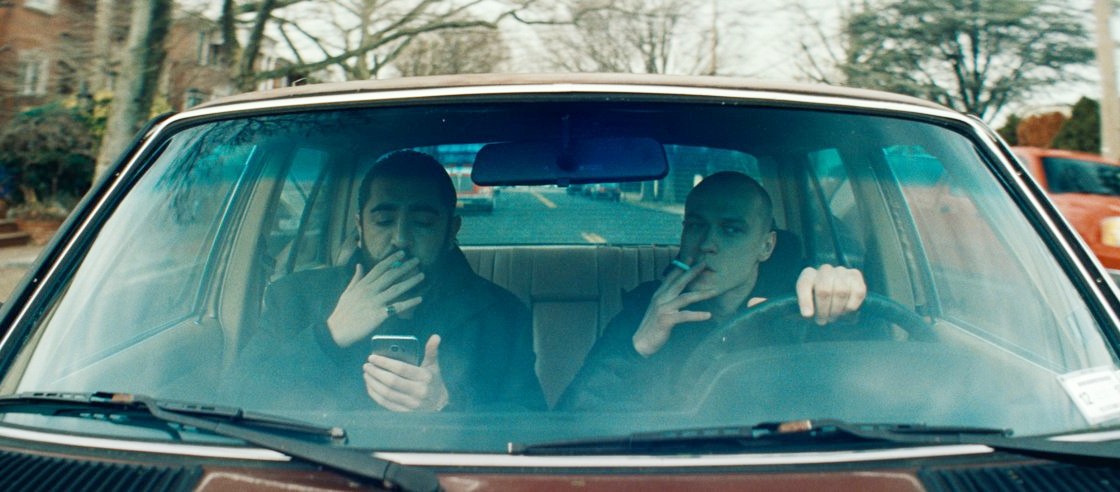 Two guys sit in a car in Anora.