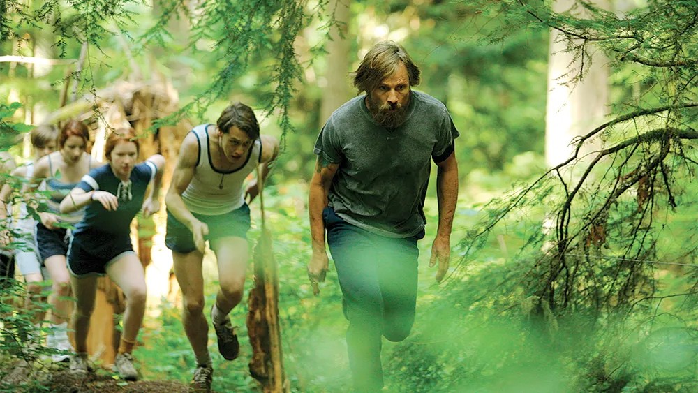 A father and his children walk in the woods in Captain Fantastic.