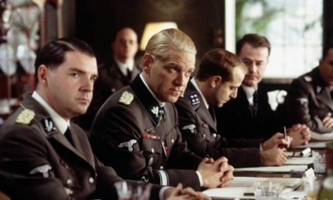 A group of men sit at a table in Conspiracy.