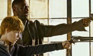 A man and a boy aim their guns in The Dark Tower.