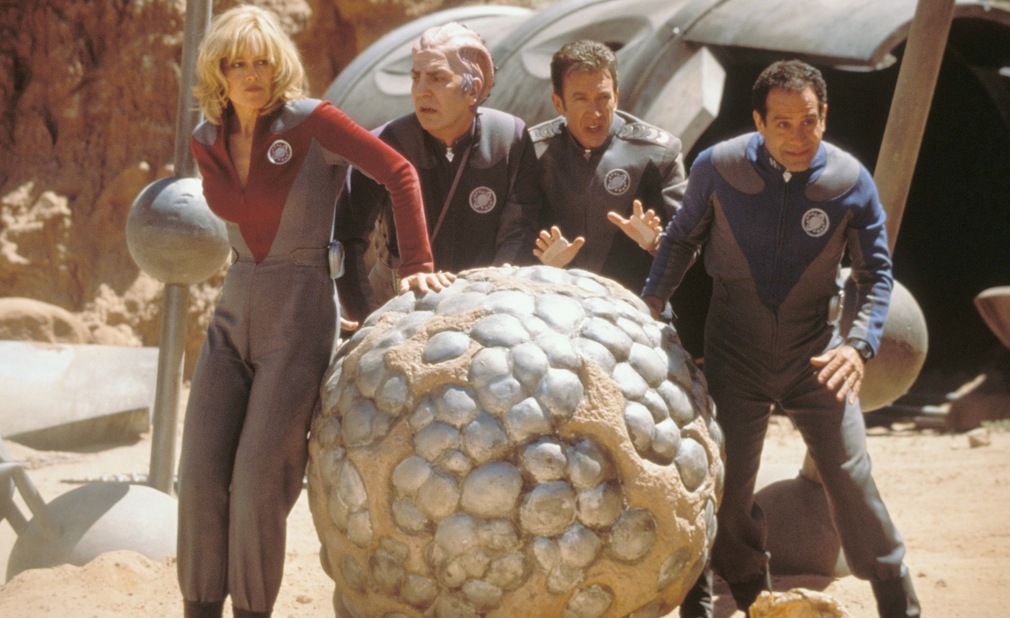 Quatre personnes se reposent sur un rocher extraterrestre dans Galaxy Quest.