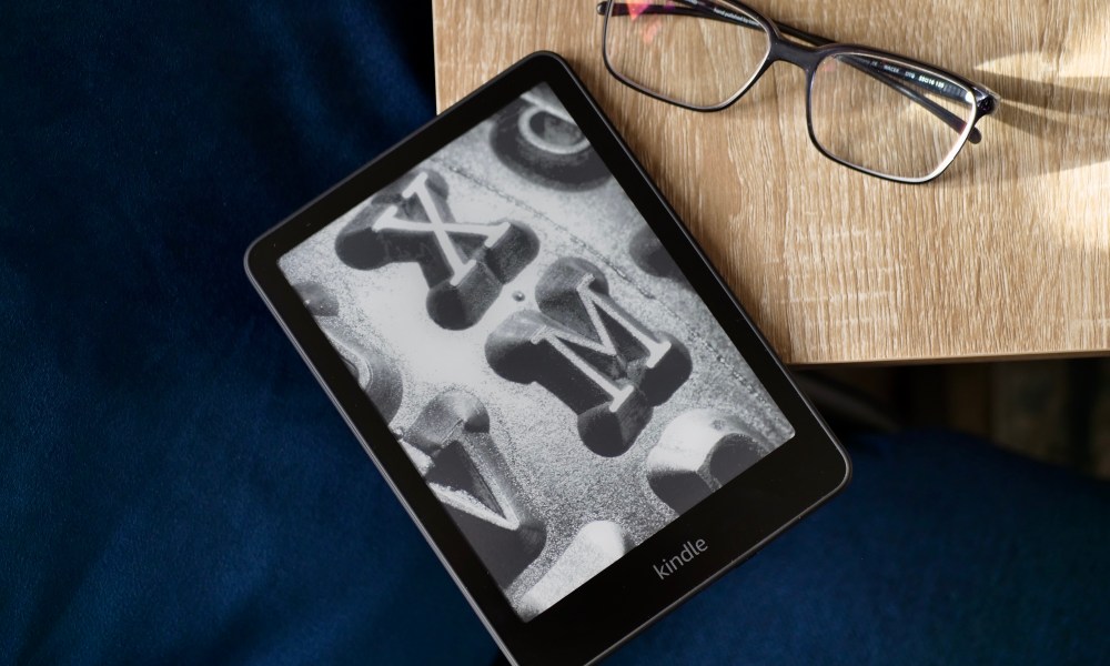 The Amazon Kindle Paperwhite 2024 on a table with a pair of glasses.