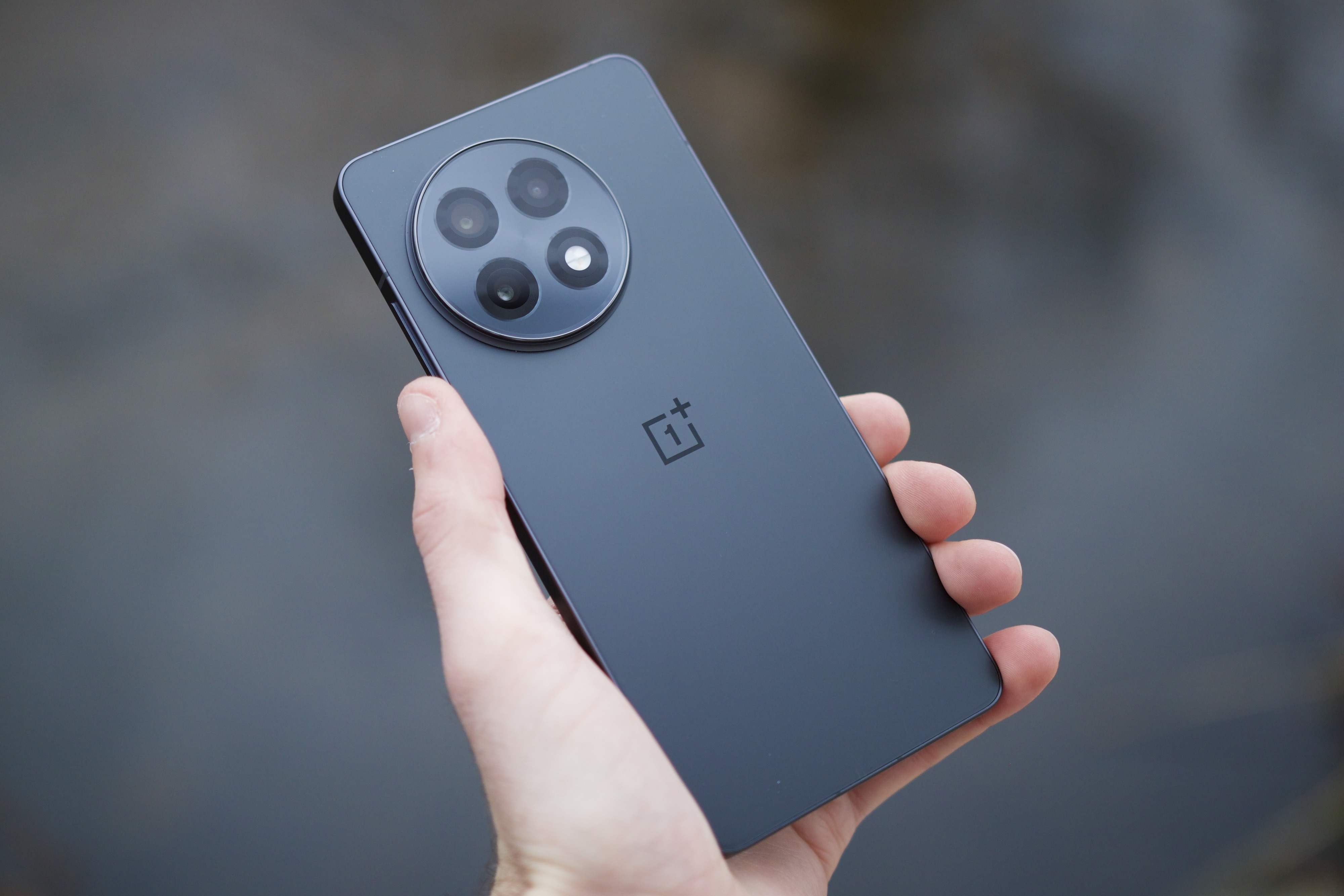 Кто-то держит OnePlus 13R и показывает заднюю часть телефона.