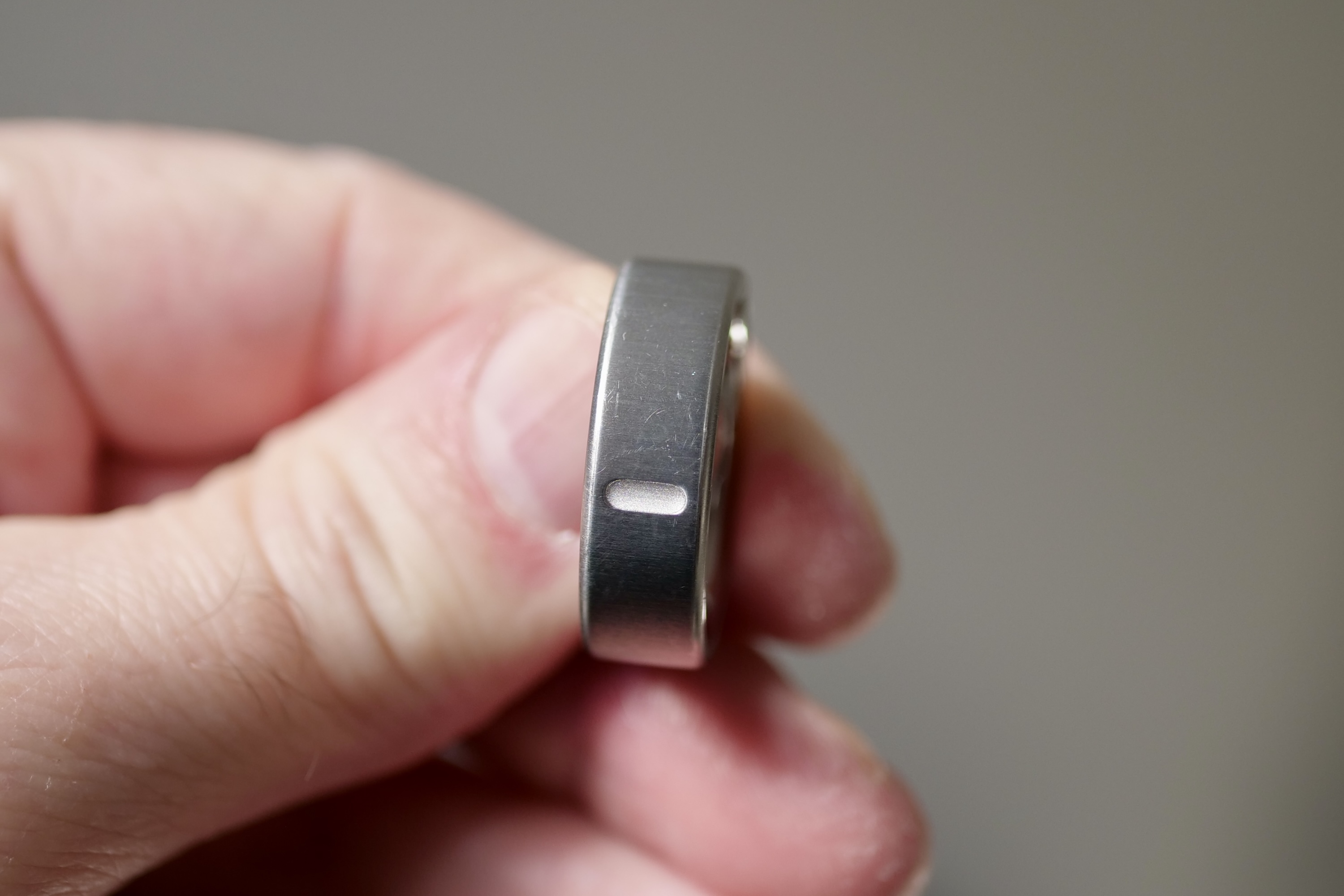 A person holding the Oura Ring 4, showing surface scratches.