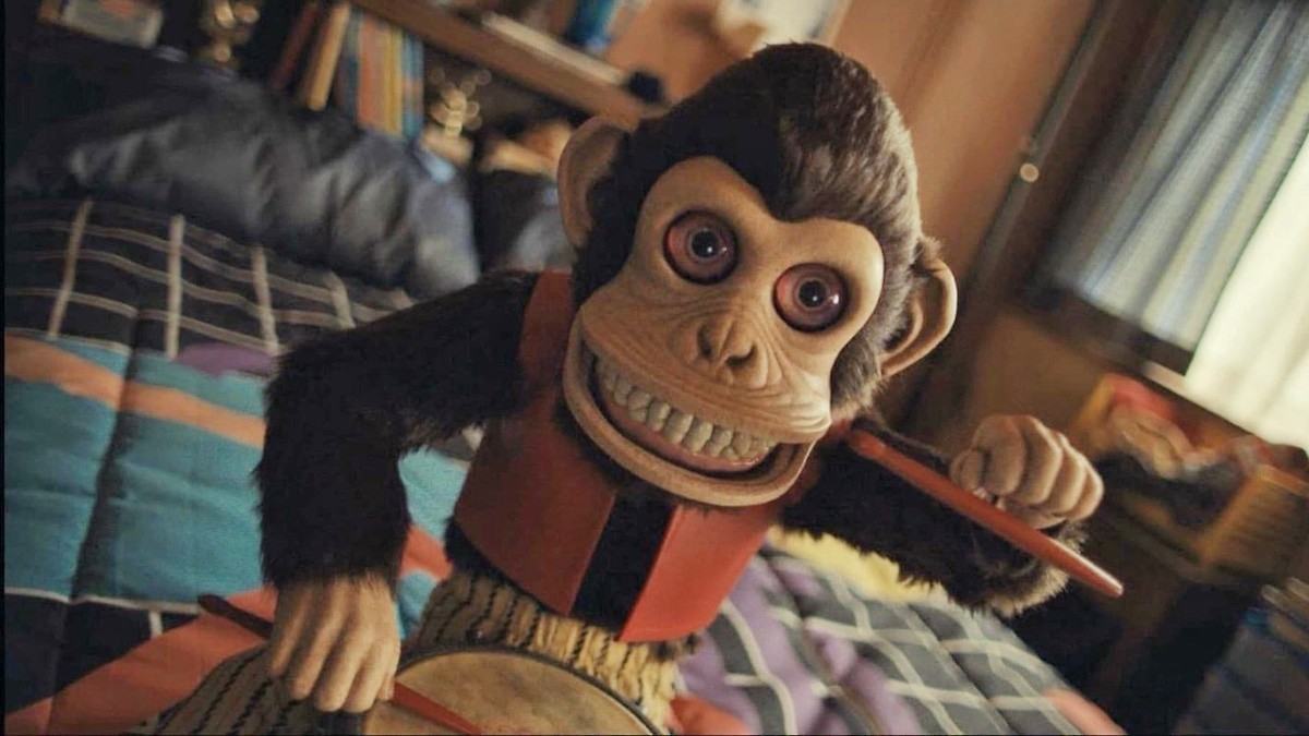 Um macaco de brinquedo sorri em O Macaco.