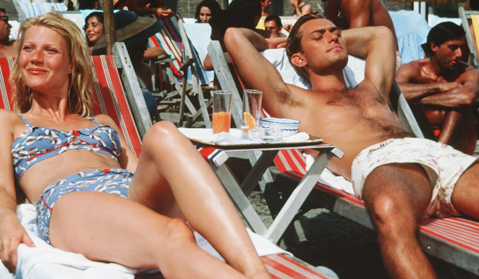 Un hombre y una mujer yacen en una playa en The Talented Mr. Ripley.