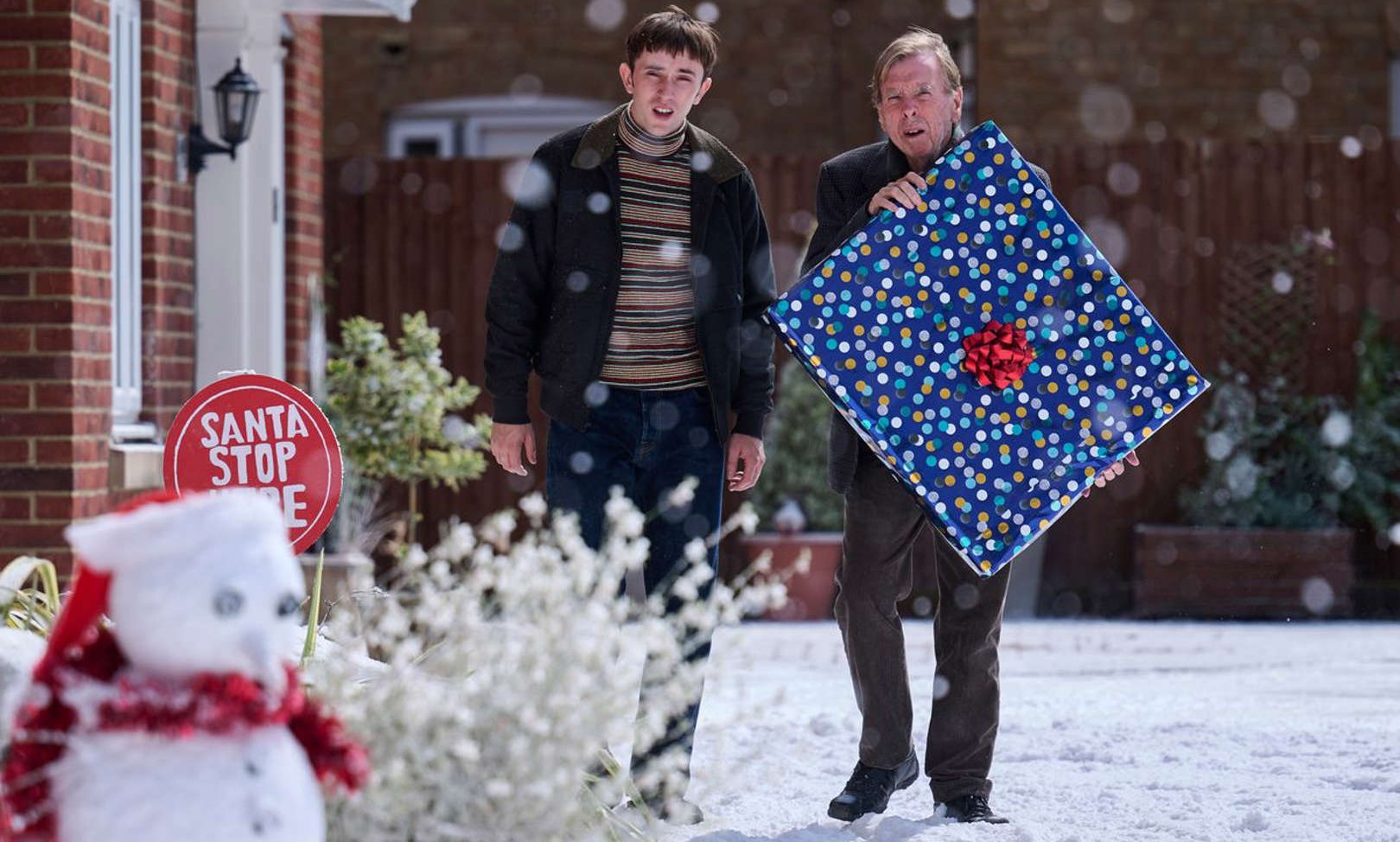 Two men carry a present in This is Christmas.