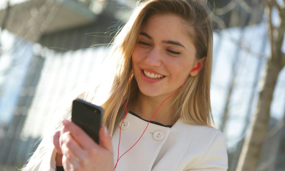 Woman smiling at phone used for RedPocket Mobile article.