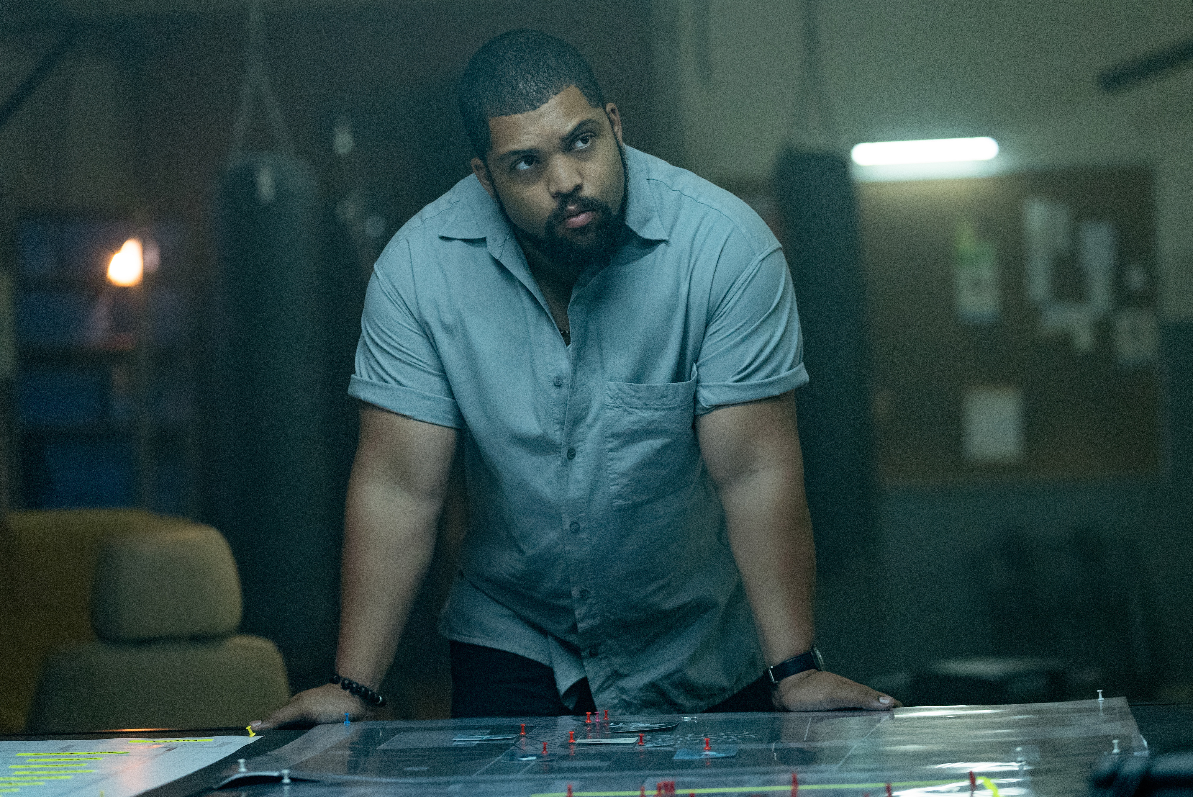 O'Shea Jackson Jr como Donnie Wilson em pé acima de uma mesa em Den of Thieves 2.