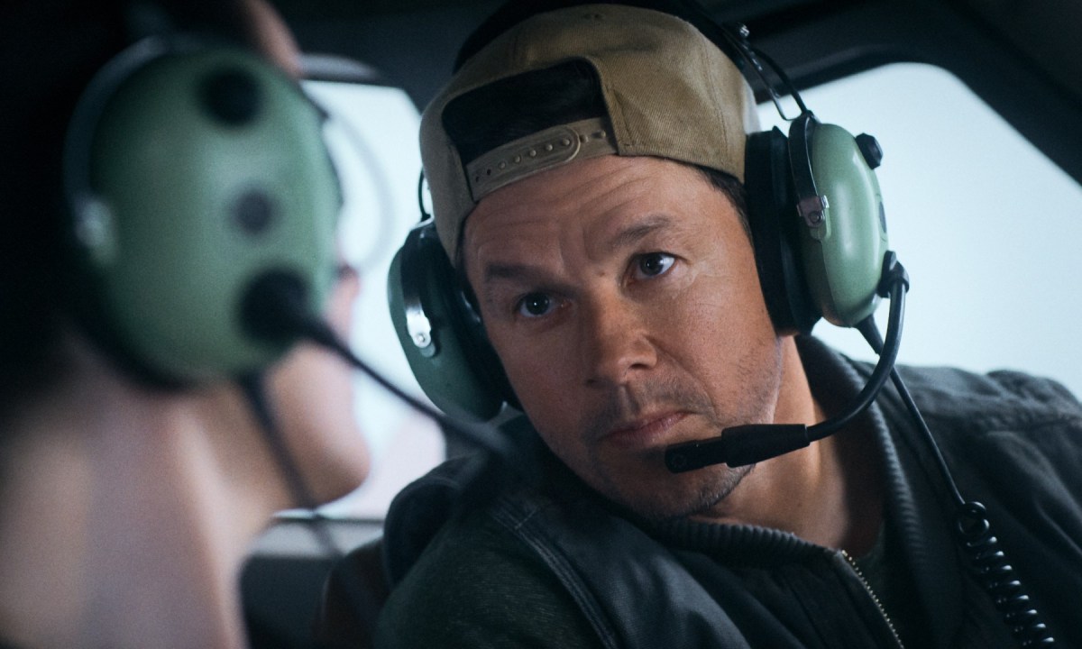 Mark Wahlberg talks into an airplane headset in a still from the movie Flight Risk.