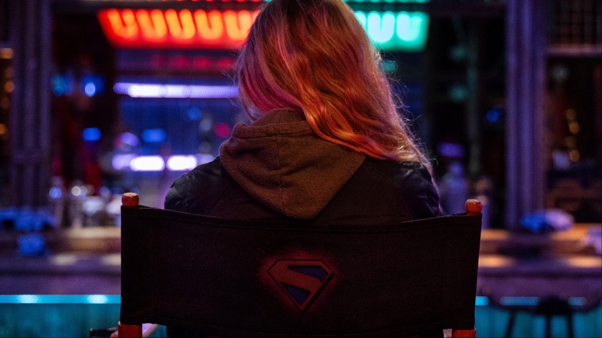 Le dos de Milly Alcock avec une veste Supergirl.