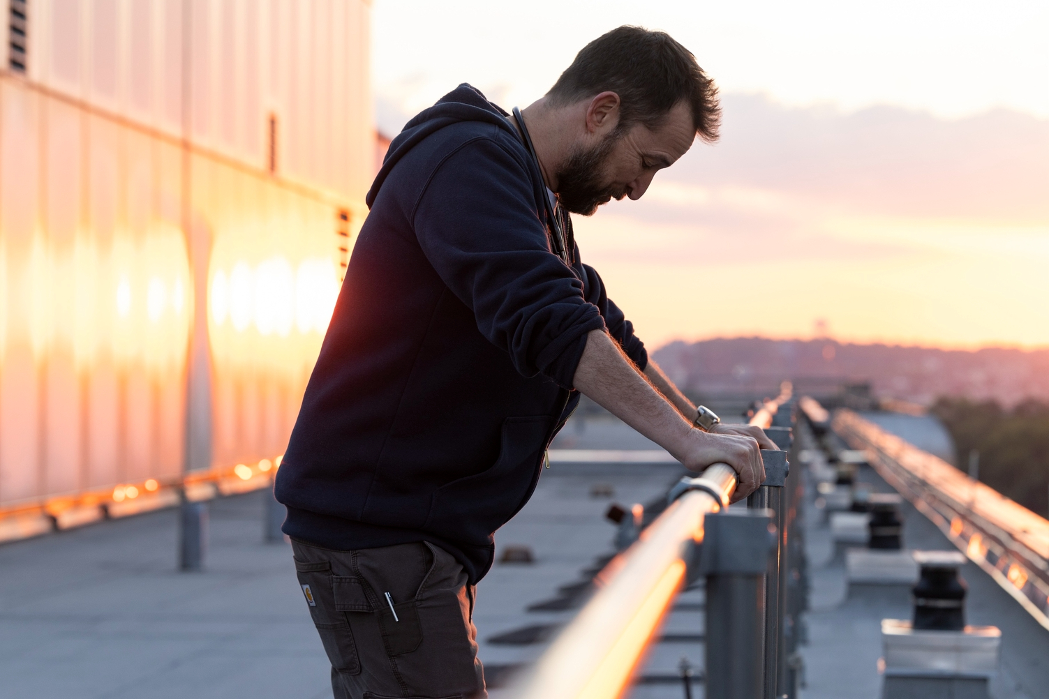 Noah Wyle stands alone on a rooftop in The Pitt.