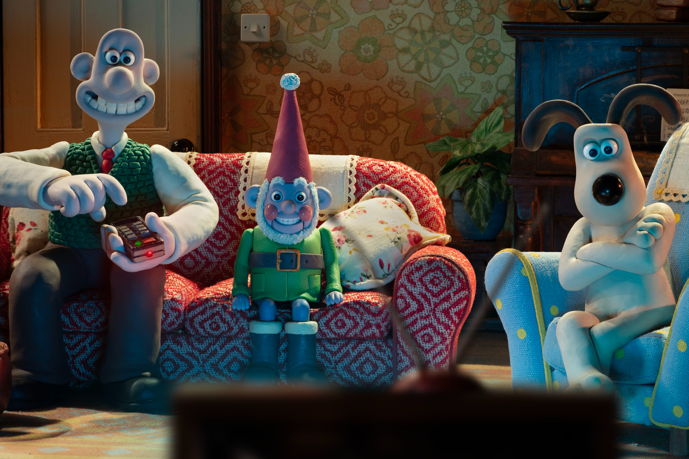 Norbot se sienta en un sofá en Wallace & Gromit: Vengeance Most Fowl.