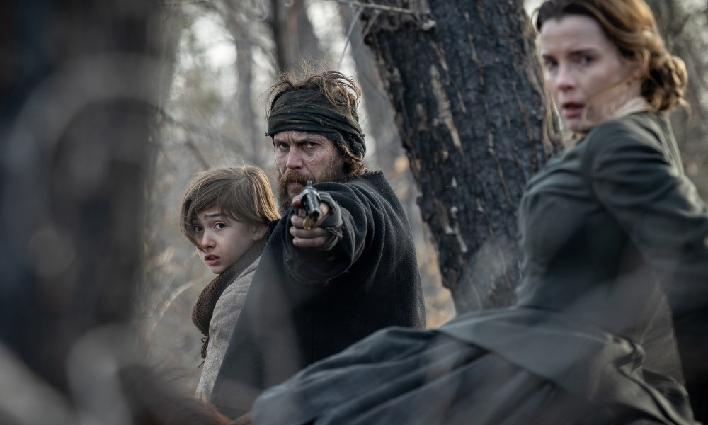 Taylor Kitsch points a gun next to Betty Gilpin in American Primeval.