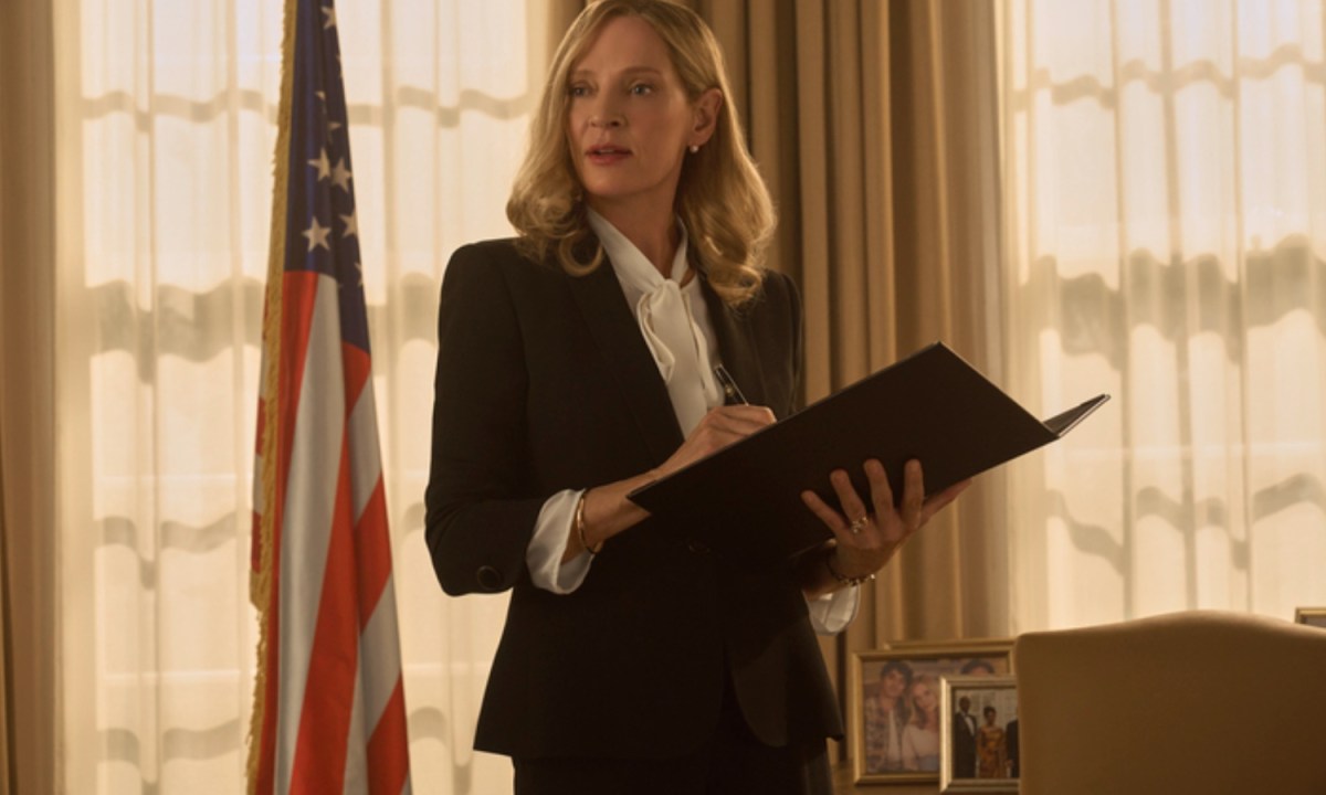 Uma Thurman holds a clip board in Red, White, and Royal Blue.