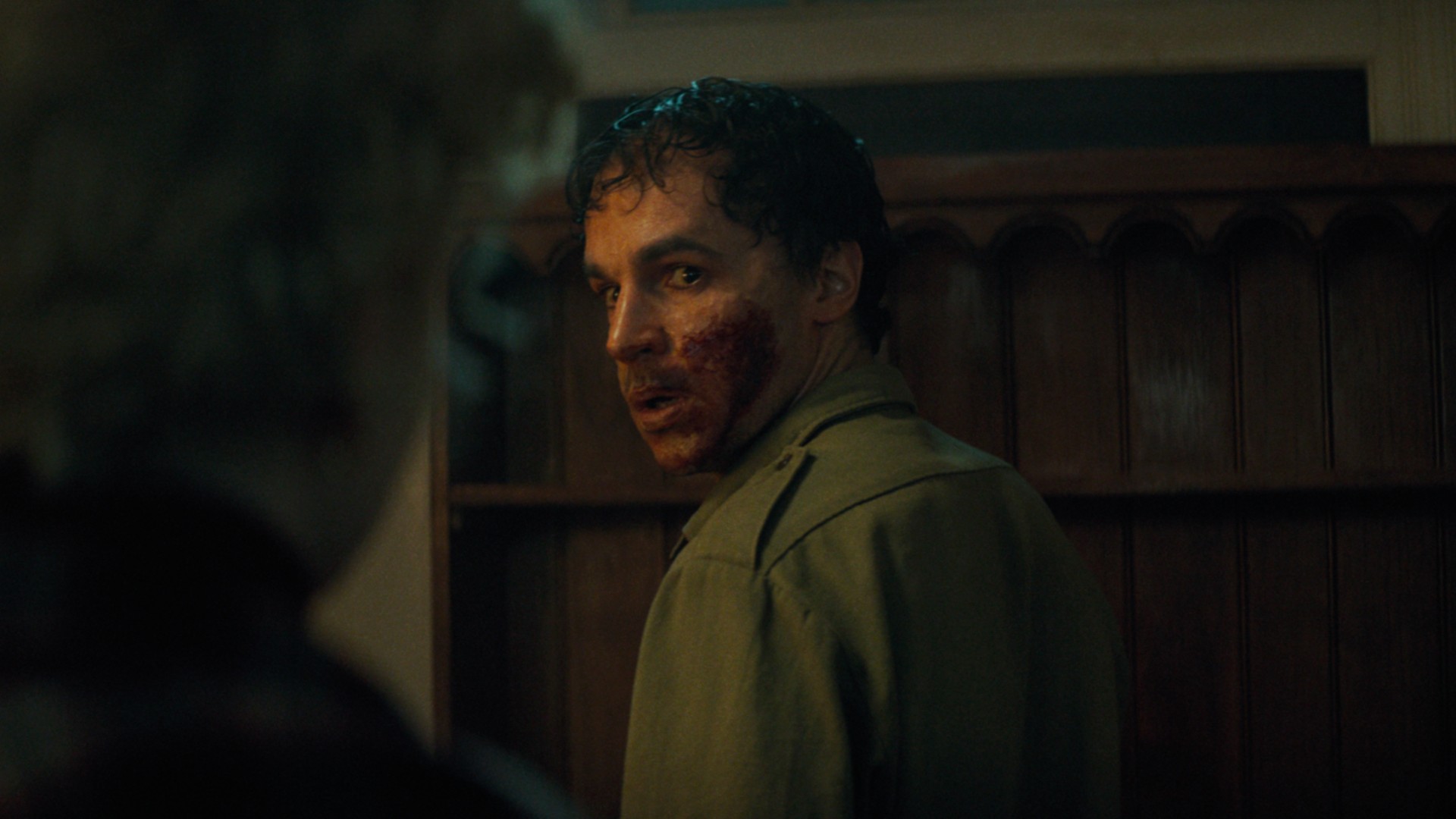 Christopher Abbott stares back at Julia Garner, his mouth caked in blood, in a still from the movie Wolf Man.