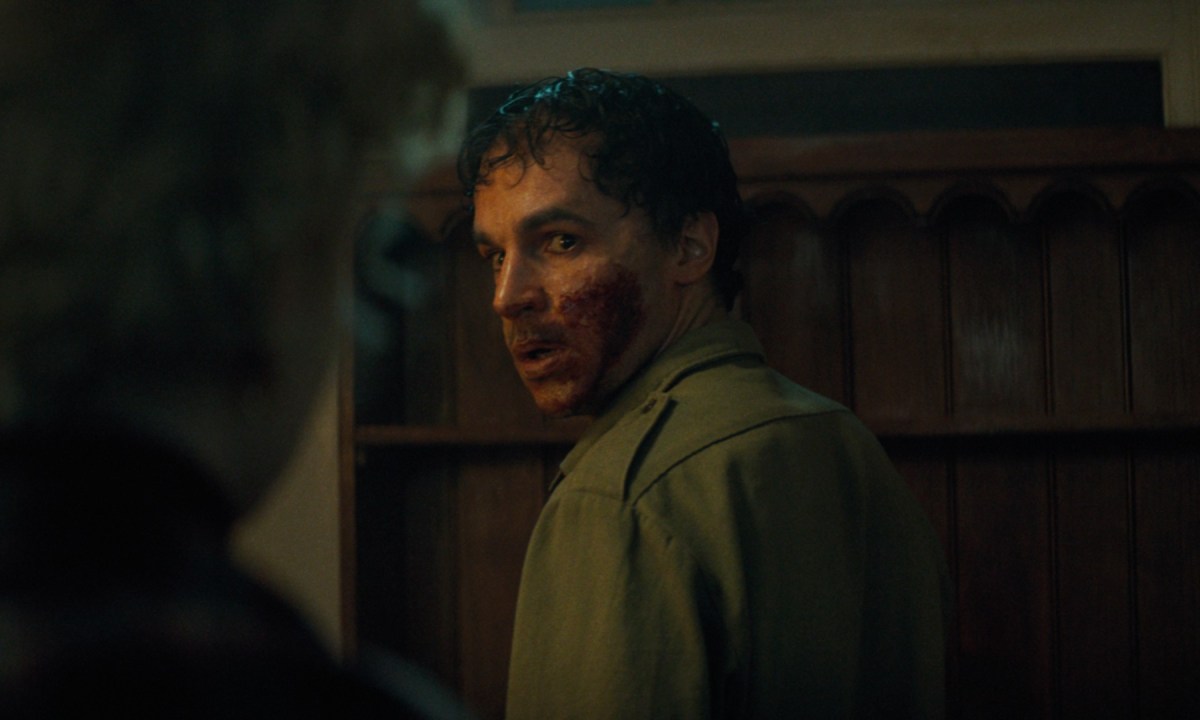 Christopher Abbott stares back at Julia Garner, his mouth caked in blood, in a still from the movie Wolf Man.