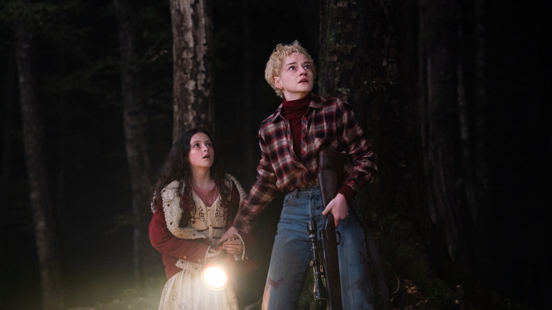 Matilda Firth et Julia Garner ont l'air effrayées dans les bois sur une photo du film Wolf Man.