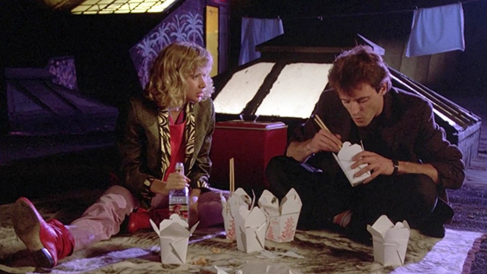 A man and a woman eat food on the floor in Desperately Seeking Susan.