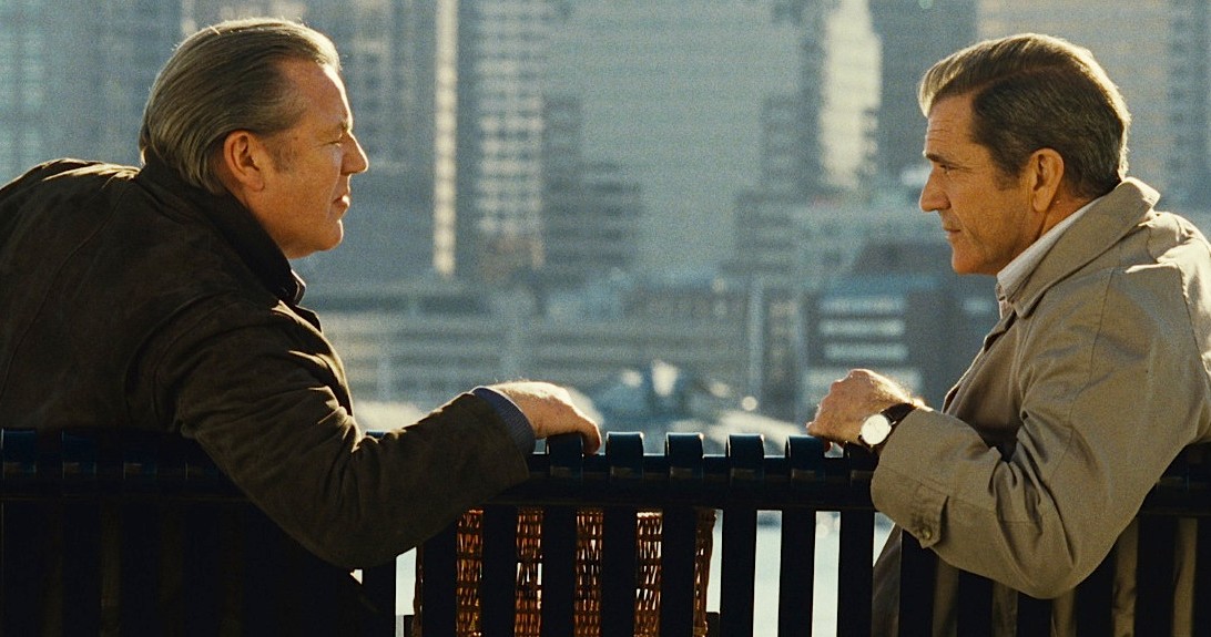 Dos hombres se sientan y se miran en Edge of Darkness.