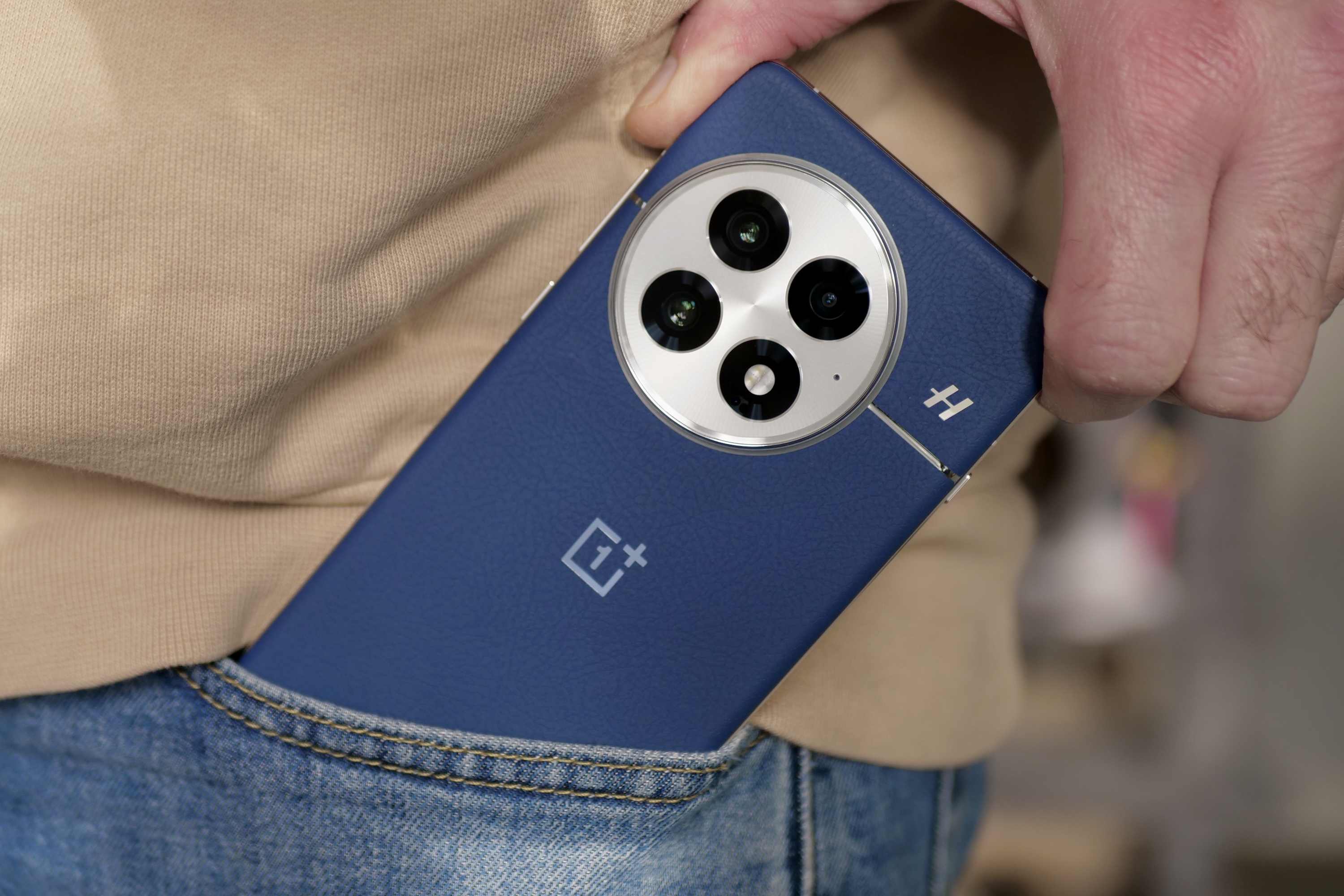 A person taking the OnePlus 13 out of a pocket.