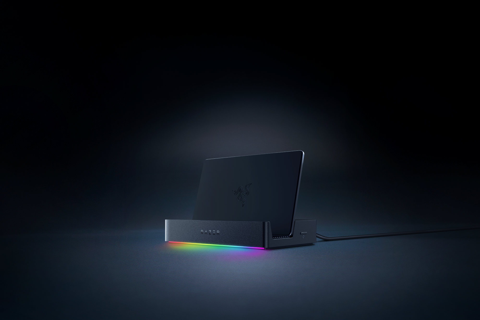 Un Razer Handheld Dock Chroma se trouve sur une surface noire.