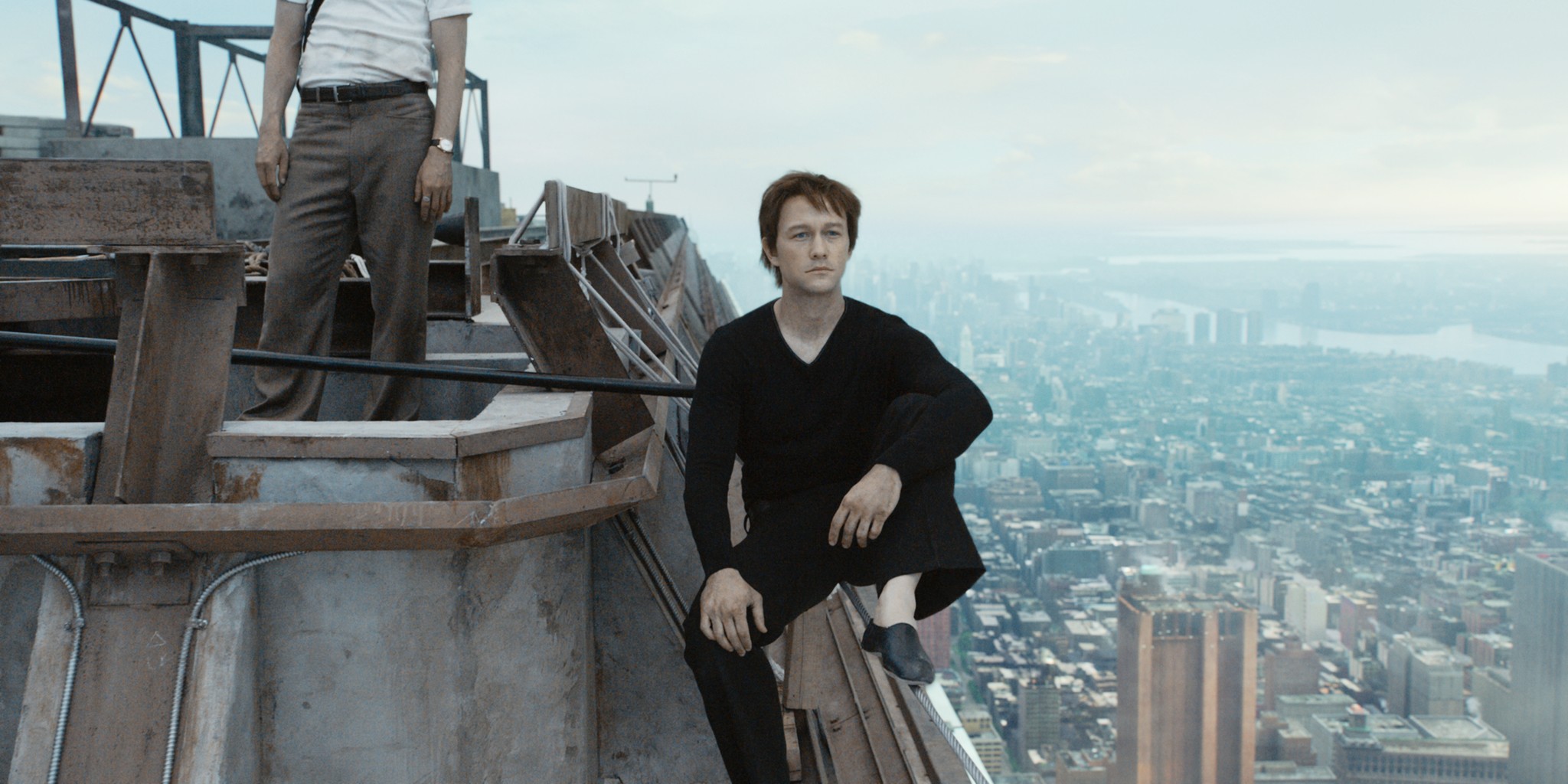 Мужчина сидит на здании в The Walk.