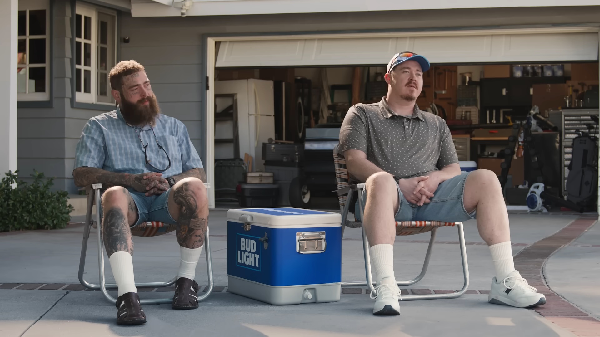 Post Malone et Shane Gillis assis ensemble dans une publicité pour Bud Light.