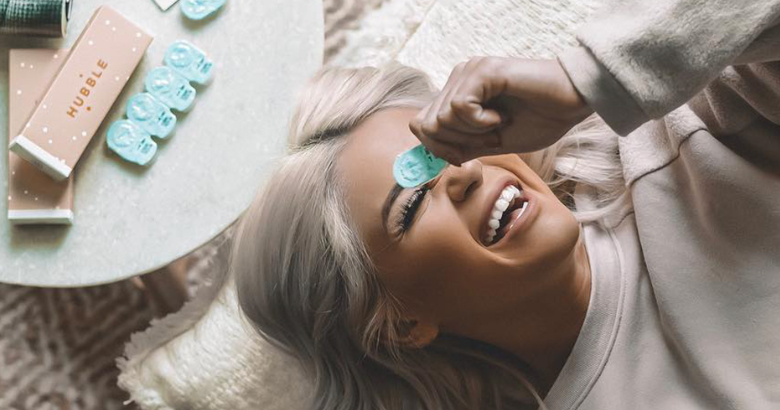 mulher segurando um estojo de lentes de contato sobre o rosto