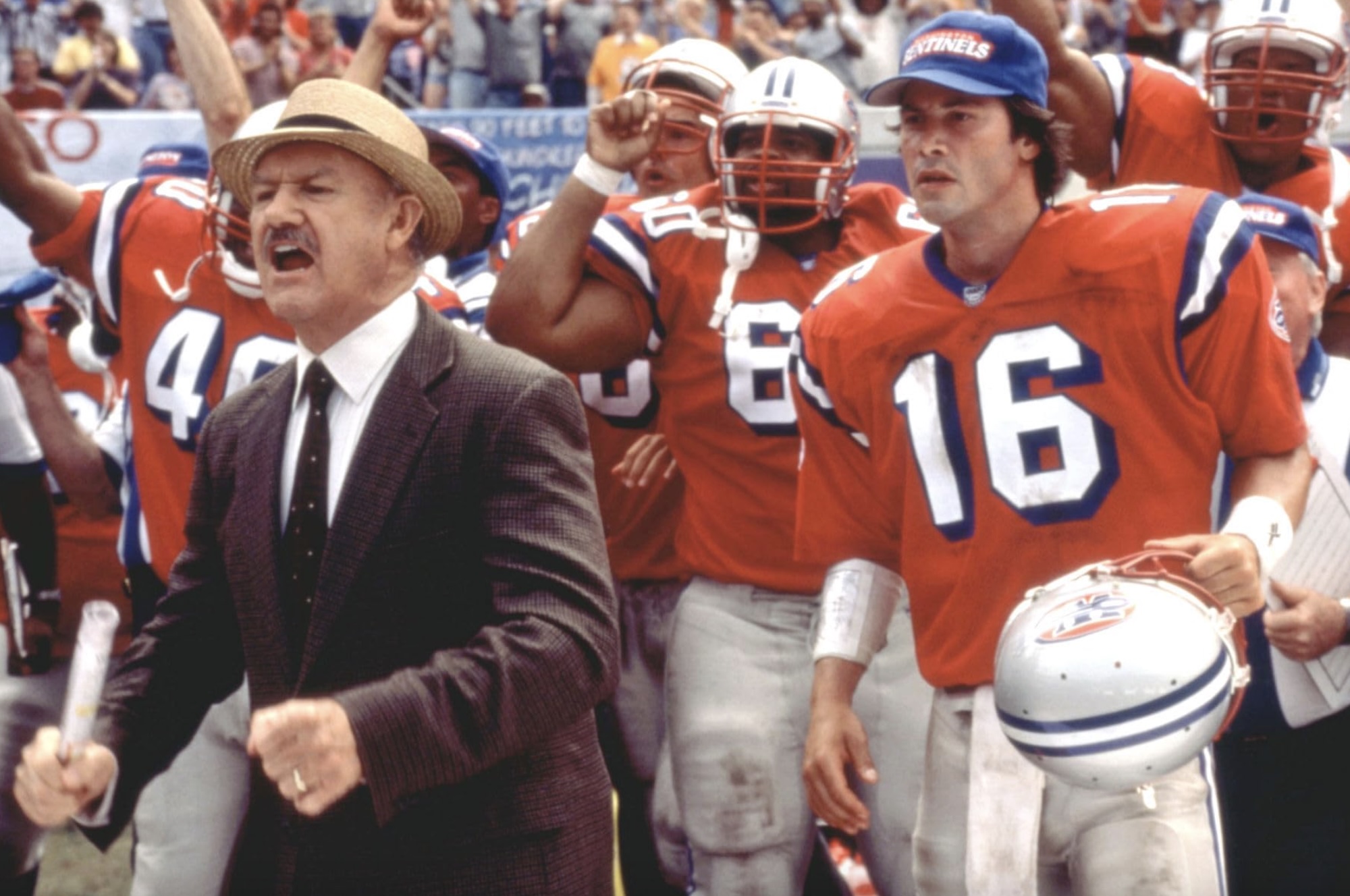 A coach cheers a his quarterback stands bheind him in The Replacements.