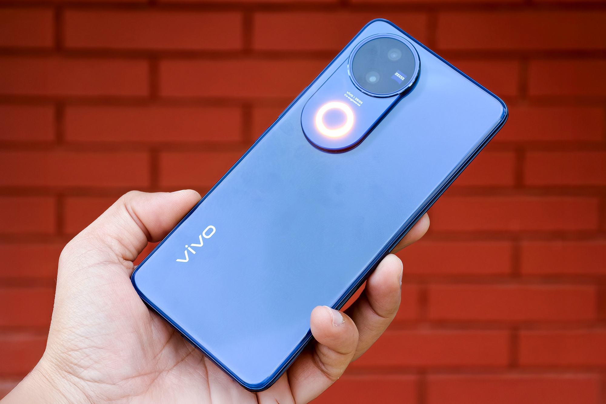 Vivo V50 bleu céleste avec Aura Light tenu en main.