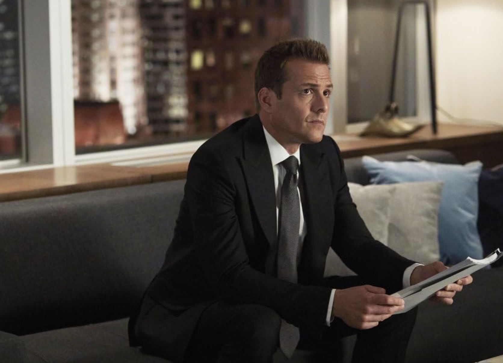 Gabriel Macht senta em um sofá em Suits.