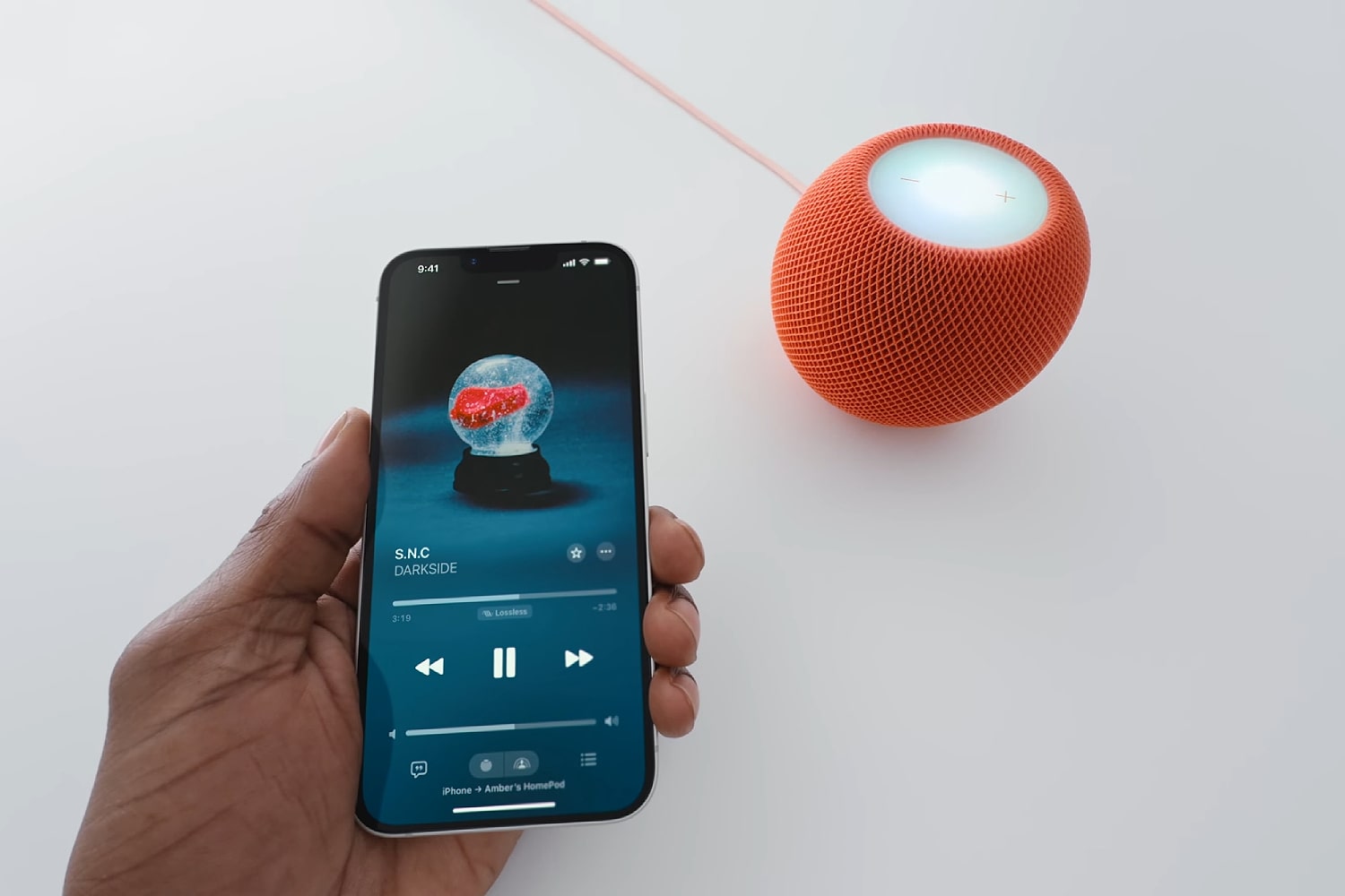 Eine Person hält ein iPhone 16e an einen HomePod mini.